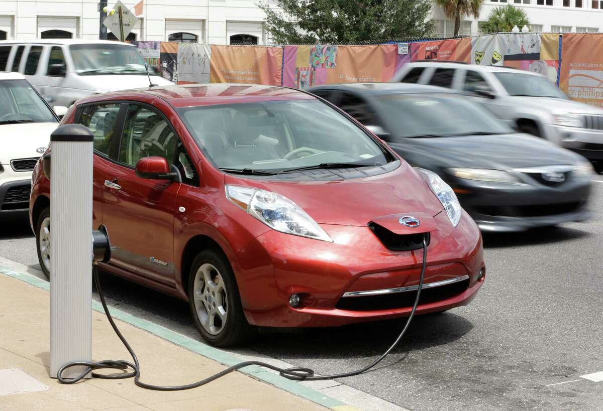 An electric car gets charged in Orlando, Fla. The tourist town is home to an electric rental car initiative in which the cars are powered up for free.