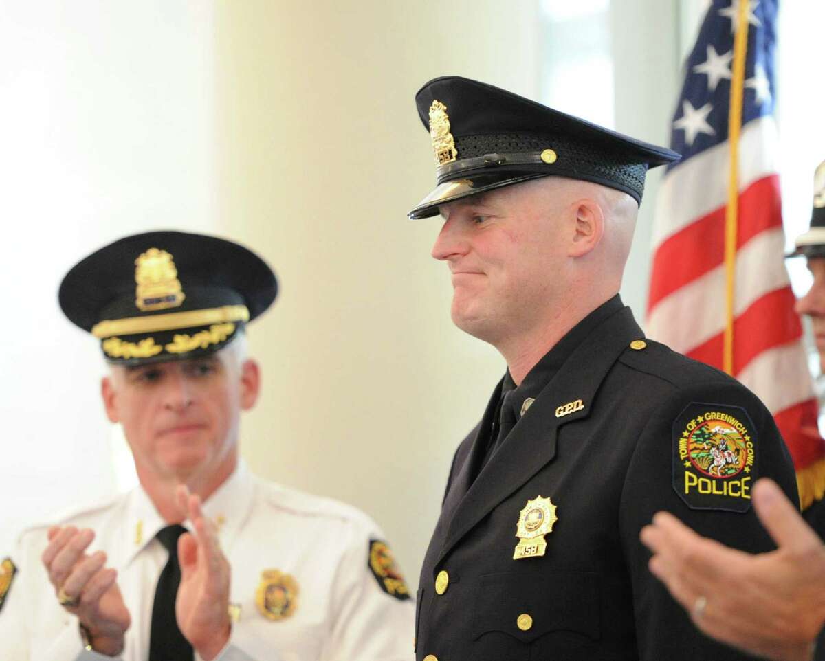At left, Greenwich Police Chief James Heavey applaudes just after Greenwich Police Officer Ernest Mulhern, right, was promoted to rank of Sergeant during a ceremony at Greenwich Police Headquarters, Thursday, Sept. 5, 2013.