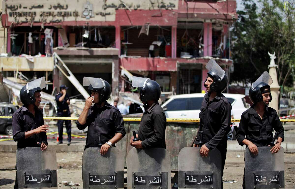 Egyptian officers guard the scene of a bomb attack targeting the convoy of Egypt's Interior minister.