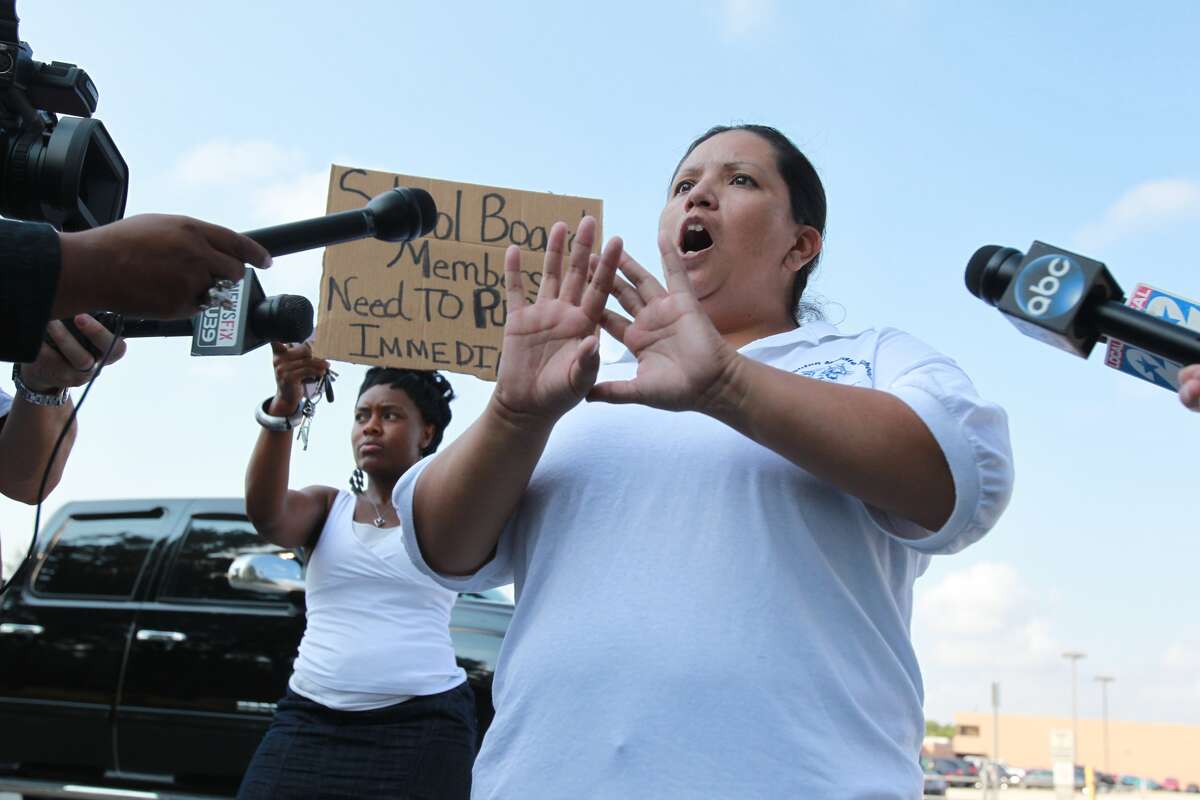 Protesters stand outside Spring High School on Thursday, Sept. 5, 2013, the morning after one student was killed and three others injured in a campus stabbing.