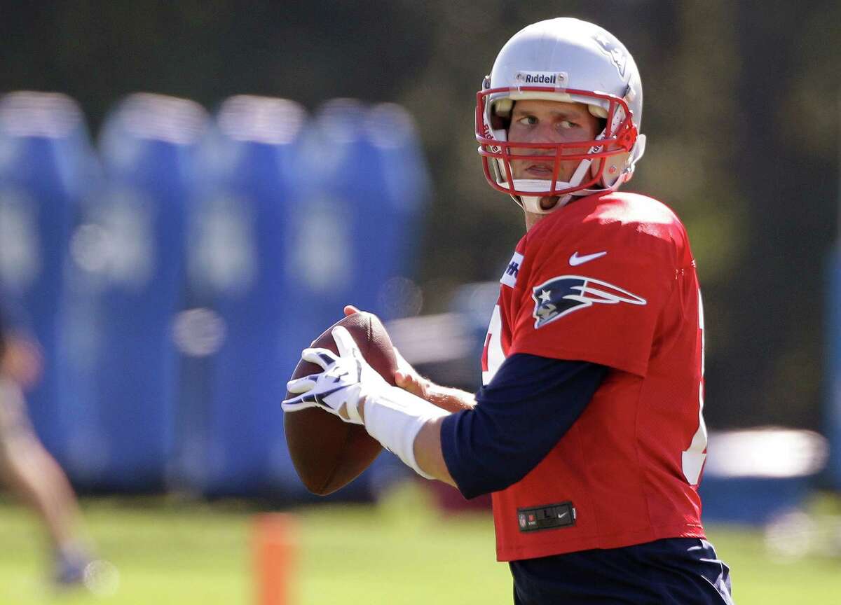 New England Patriots quarterback Tom Brady (12) throws a ball during stretching exercises before practice at the NFL football team's facility in Foxborough, Mass., Wednesday Sept. 4, 2013. The Patriots open their regular season against the Buffalo Bills on Sunday. (AP Photo/Stephan Savoia)