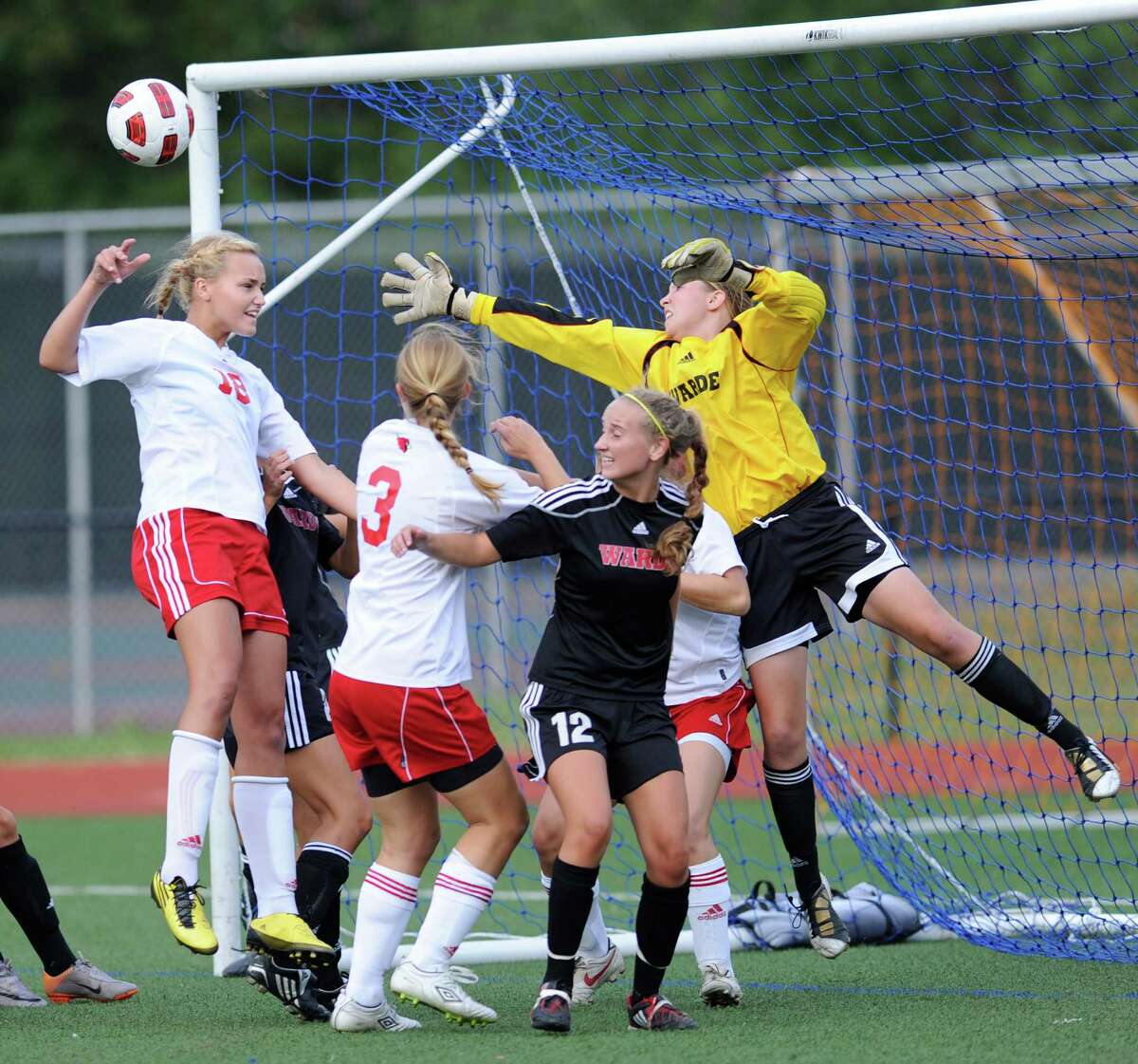 All-FCIAC goalie Katie Brennan, in yellow, reaching for the ball, again backstops a strong Fairfield Warde defense that has the Mustangs expecting big things in 2013.