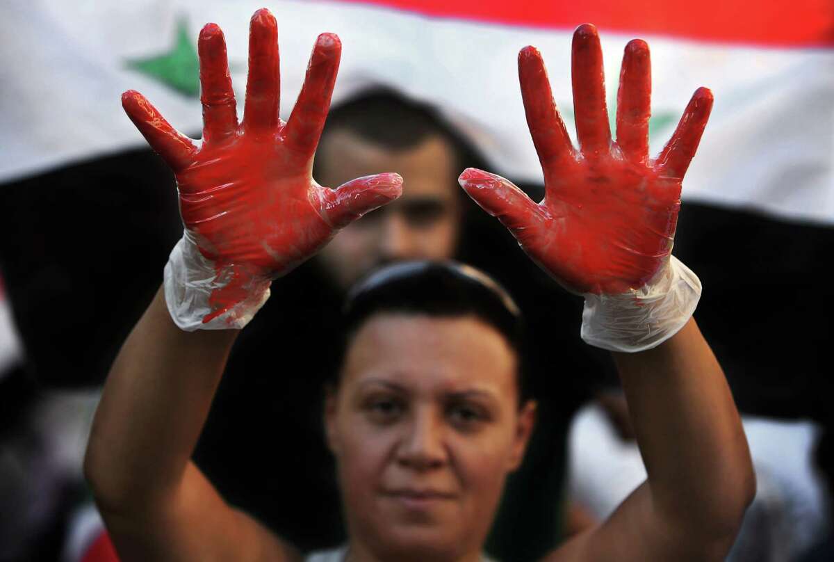 A Lebanese pro-Syrian regime supporter, with their hands painted in red to symbolize blood, attends a demonstration against a possible military strike in Syria, near the U.S. Embassy in Aukar, east of Beirut, Lebanon, Friday, Sept. 6, 2013. The prospect of a U.S.-led strike against Syria has raised concerns of potential retaliation from the Assad regime or its allies. The State Department ordered nonessential U.S. diplomats to leave Lebanon over security concerns and urged private American citizens to depart as well. (AP Photo/Hussein Malla)