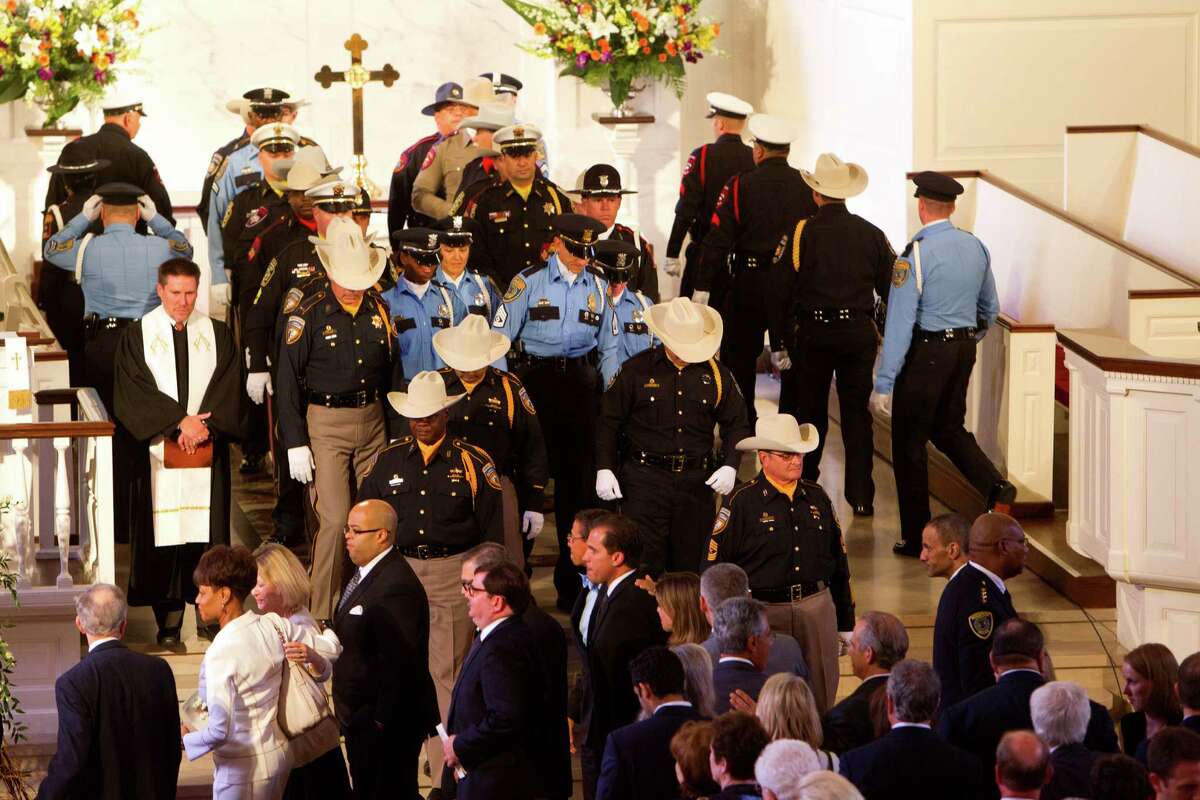Law enforcement personnel, along with other mourners, leave the First Presbyterian Church after District Attorney Mike Anderson's funeral service, Friday, Sept. 6, 2013, in Houston. Anderson died after a battle with cancer.