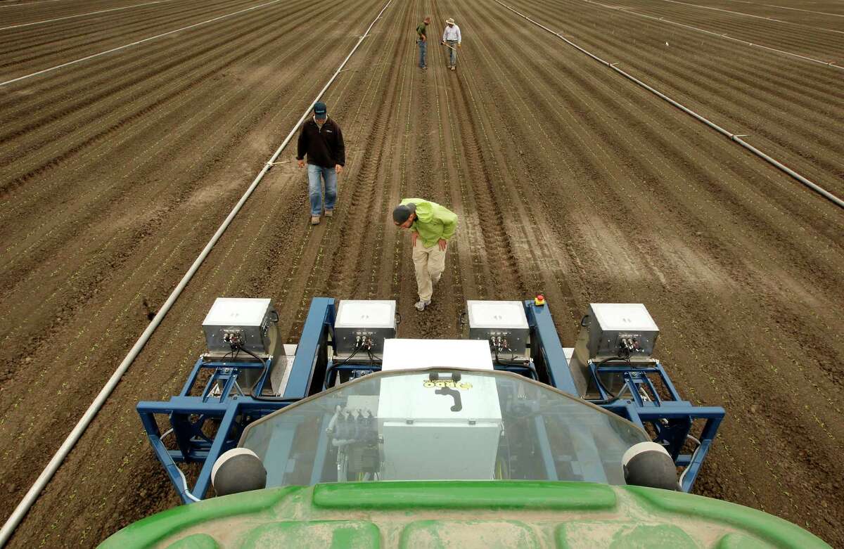 With fewer seasonal workers available, agriculture is slowly replacing humans with robotic harvesters, crop-spraying drones and automated planters like the Lettuce Bot, above, being tested in Castroville, Calif.