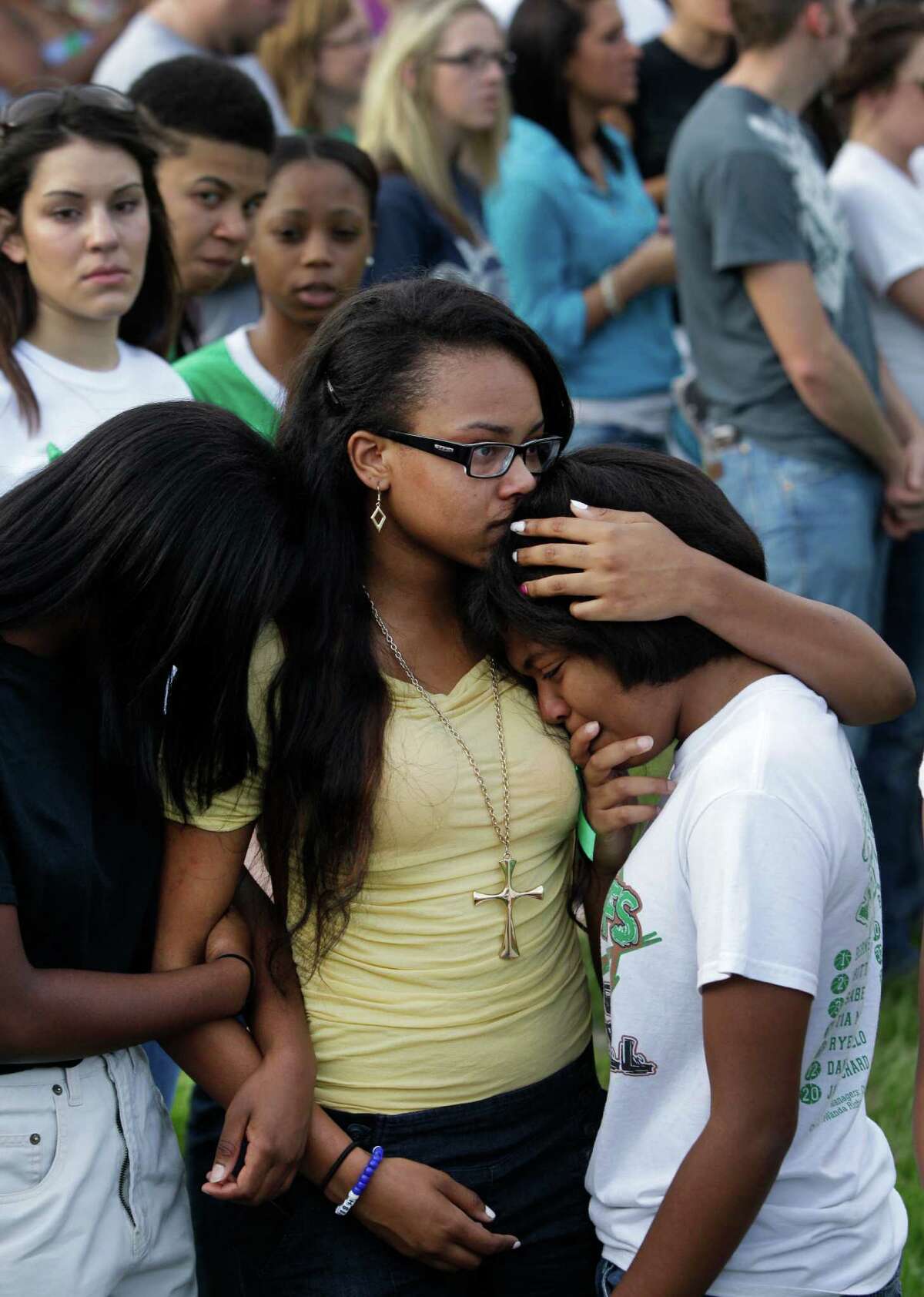 Justice Comeaux, left, a junior, Monique Sutton, center, a junior, Lavonne Williams, right, a junior, hug during gathering with more than 200 people to pray outside Spring High School Sunday, Sept. 8, 2013, in Spring. Students will return to classes on Monday to the school where Joshua Broussard, 17, a Spring High School student was fatally stabbed and three others injured at the school Wednesday, Sept. 3, 2013. Luis Alonzo Alfaro, 17, has been charged with murder.