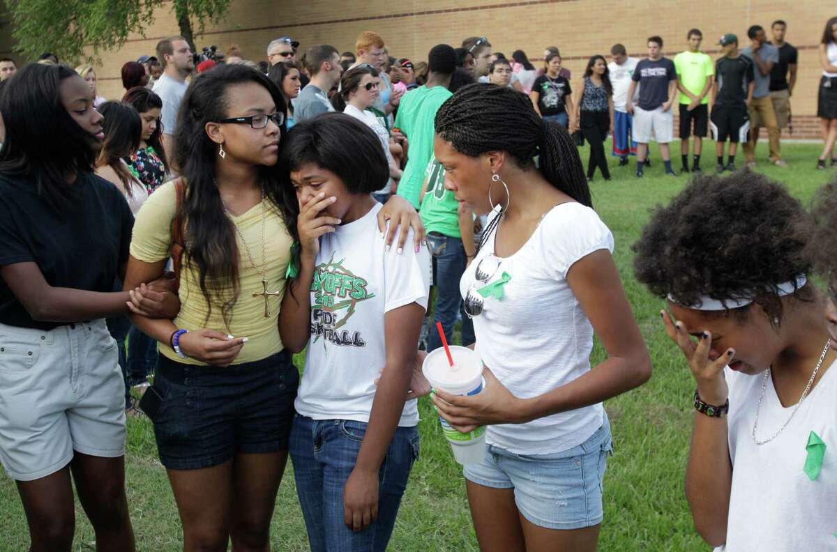 Spring High School students Justice Comeaux, left, a junior, Monique Sutton, a junior, Lavonne Williams, a junior, Chassidy Williams, a sophomore, and Bria Ferrier, right, a sophomore, comfort each other as they gather with more than 200 people to pray outside Spring High School Sunday, Sept. 8, 2013, in Spring. Students will return to classes on Monday to the school where Joshua Broussard, 17, a Spring High School student was fatally stabbed and three others injured at the school Wednesday, Sept. 3, 2013. Luis Alonzo Alfaro, 17, has been charged with murder.