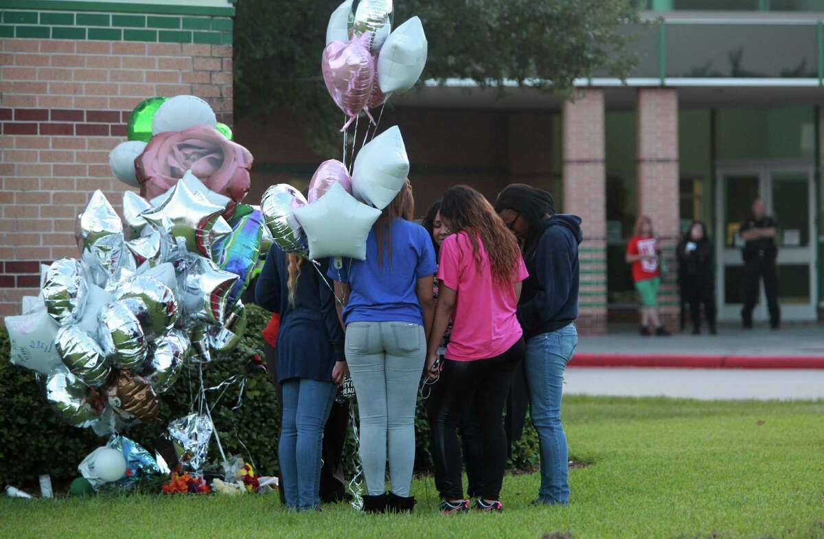 Students on Monday pray by the memorial outside Spring High School.