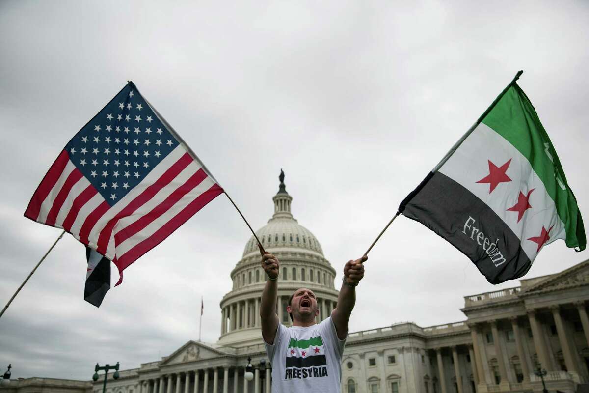 Jehad Sibai waves flags during a rally Monday on Capitol Hill in support of possible U.S. military action in Syria. President Barack Obama called a proposal by Vladimir Putin "a potentially positive development."