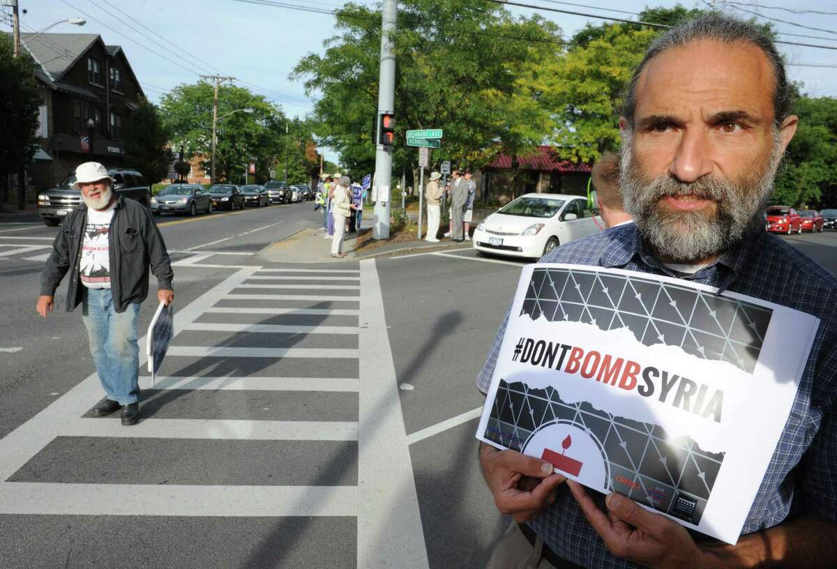 Joe Seeman of Ballston Spa holds a sign in protest to bombing Syria on Monday, Sept. 9, 2013 on Delaware Ave. in Delmar, N.Y. Residents of the Capital Region were urging Representatives Paul Tonko, Bill Owens & Chris Gibson, & Senators Charles Schumer & Kirsten Gillibrand to vote against bombing Syria. Other protest and vigils were held in various locations throughout the Capital Region. (Lori Van Buren / Times Union)