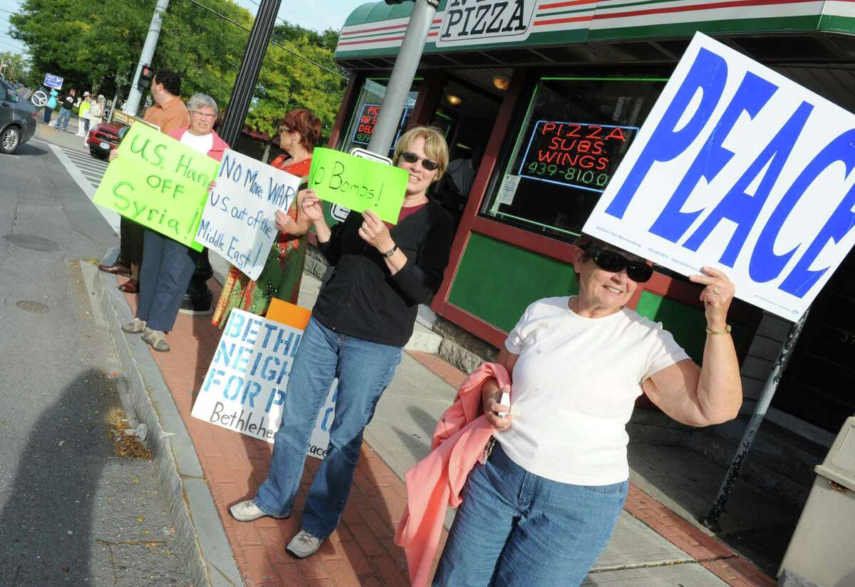 Judy Ramsey of Voorheesville, second from right, and Dianne Luci of Voorheesville, right, join residents of the Capital Region as they hold signs in protest to bombing Syria on Monday, Sept. 9, 2013 on Delaware Ave. in Delmar, N.Y. They were urging Representatives Paul Tonko, Bill Owens & Chris Gibson, & Senators Charles Schumer & Kirsten Gillibrand to vote against bombing Syria. Other protest and vigils were held in various locations throughout the Capital Region. (Lori Van Buren / Times Union)