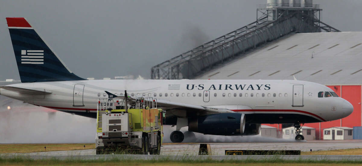 A U.S. Airways passenger jet lands safely at San Antonio International Airport Tuesday about 9 a.m. Sept. 10, 2013, as emergency vehicles stand by. 