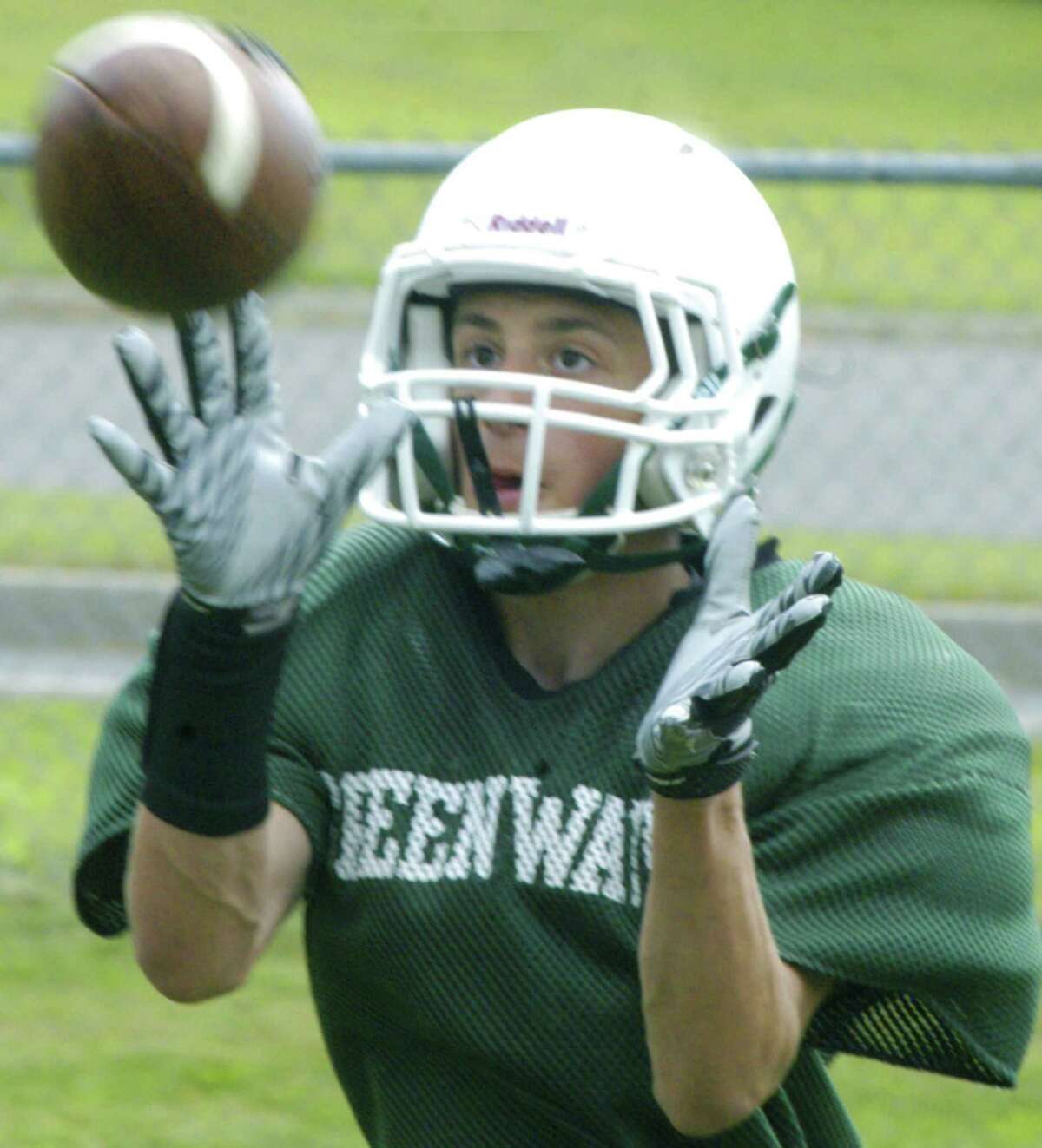 The Green Wave's Michael Carrozza focuses on the catch during pre-season drills for New Milford High School football, September 2013