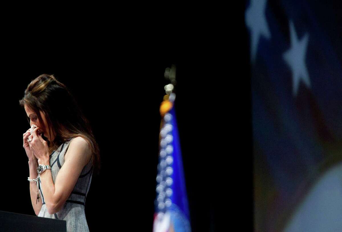Taya Kyle, the wife of slain Navy SEAL sniper Chris Kyle wipes tears from her eyes as she spoke during the NRA-ILA Leadership Forum at the National Rifle Association's 142 Annual Meetings and Exhibits in the George R. Brown Convention Center Friday, May 3, 2013, in Houston. The 2013 NRA Annual Meetings and Exhibits runs from Friday, May 3, through Sunday, May 5. More than 70,000 are expected to attend the event with more than 500 exhibitors represented. The convention will features training and education demos, the Antiques Guns and Gold Showcase, book signings, speakers including Glenn Beck, Ted Nugent and Sarah Palin as well as NRA Youth Day on Sunday ( Johnny Hanson / Houston Chronicle )