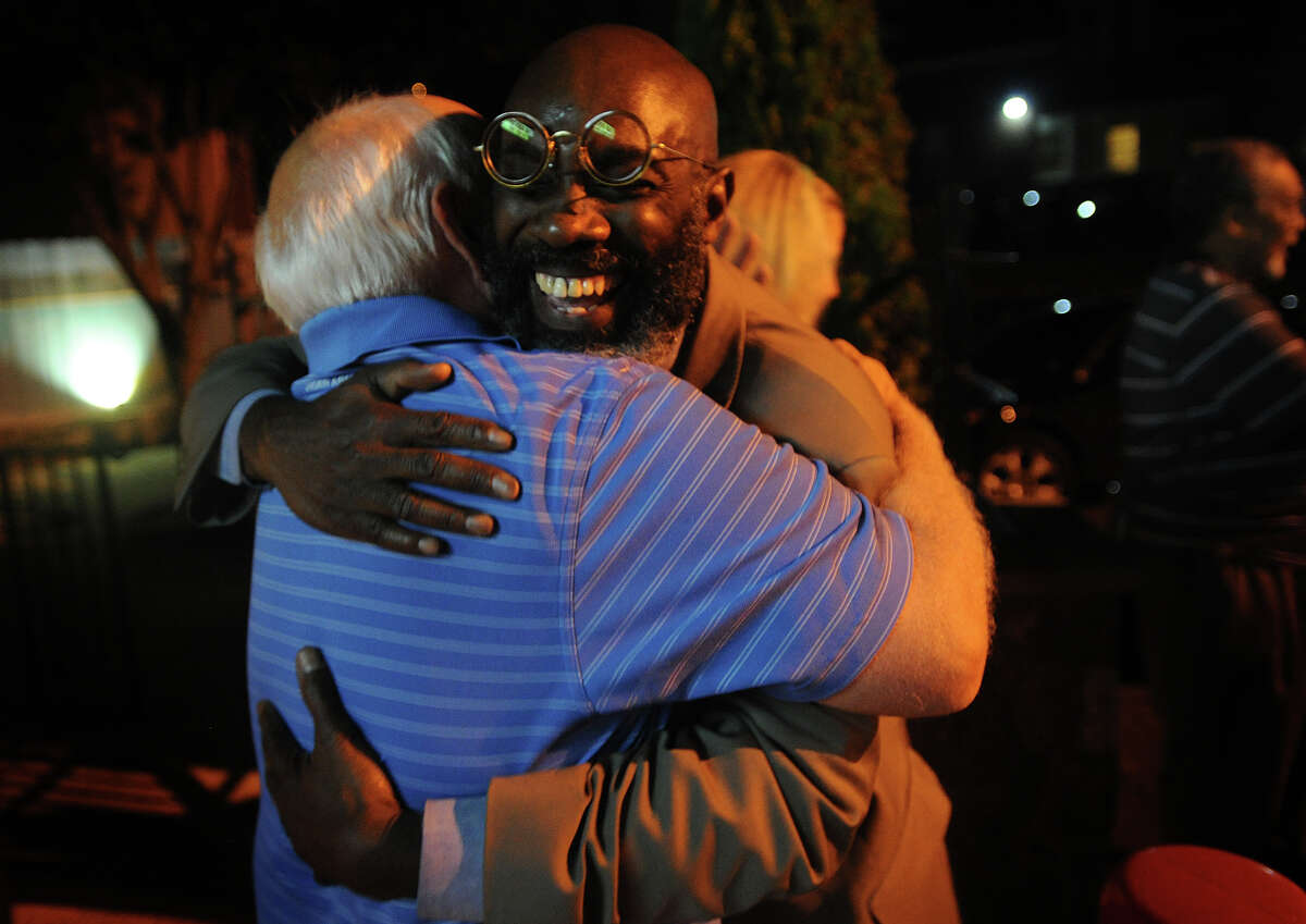 Howard Gardner, facing, is hugged by former city councilman Bob Walsh at the Red Rooster Deli in Bridgeport, Conn. after Gardner and fellow challengers Andre Baker and Dave Hennessey won the Democratic primary for Board of Education on Tuesday, September 10, 2013.