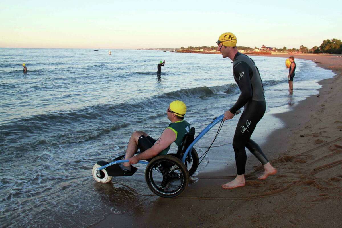 Mike Loura and Steve Joly make their way into the Long Island Sound for a half-mile swim for the 28th Annual Dave Parcells Madison triathlon on Saturday, Sept. 7.