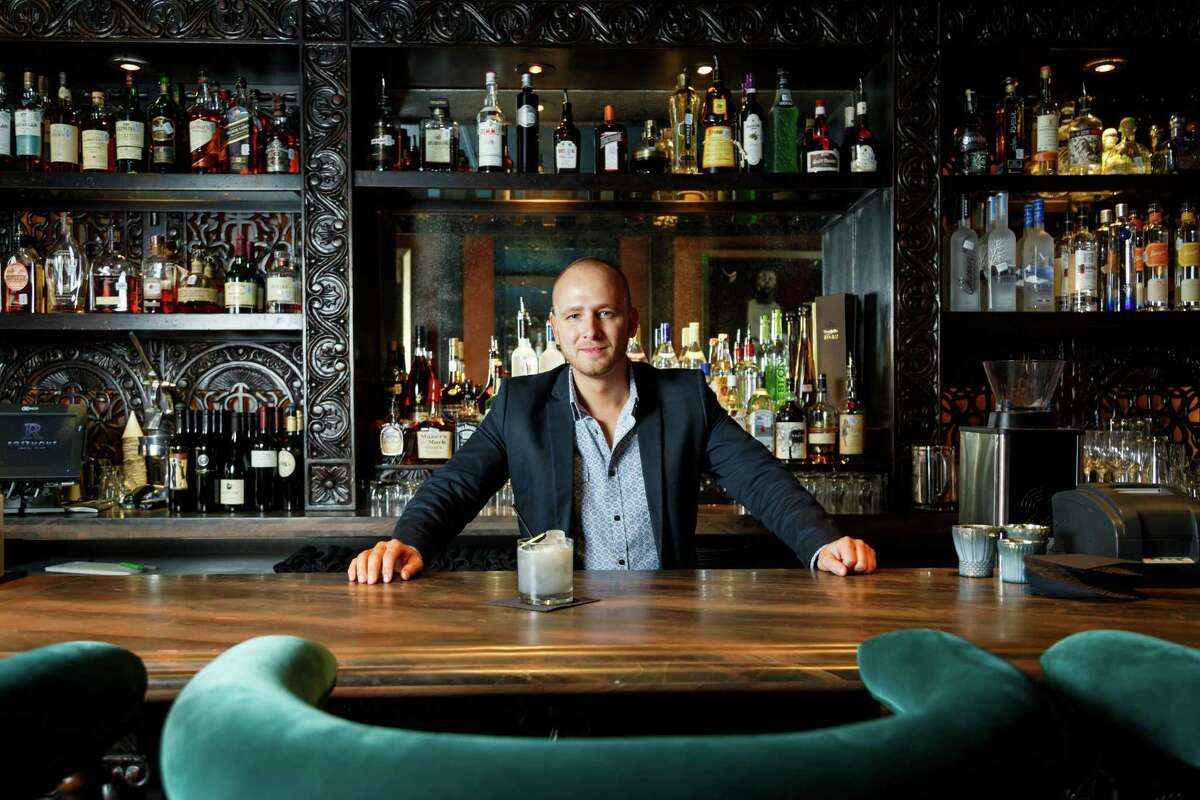 Mixologist Curtis Childress created the modern craft cocktail menu at Rosemont Social Club in Montrose. The bar's rich design features colorful furniture in turquoise and red.
