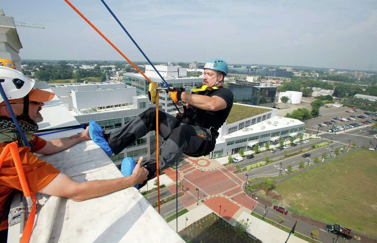 John Clapps rappels down 101 Park Place at Harbor Point in Stamford, Conn., during Over the Edge, a fundraiser for Special Olympics Connecticut.