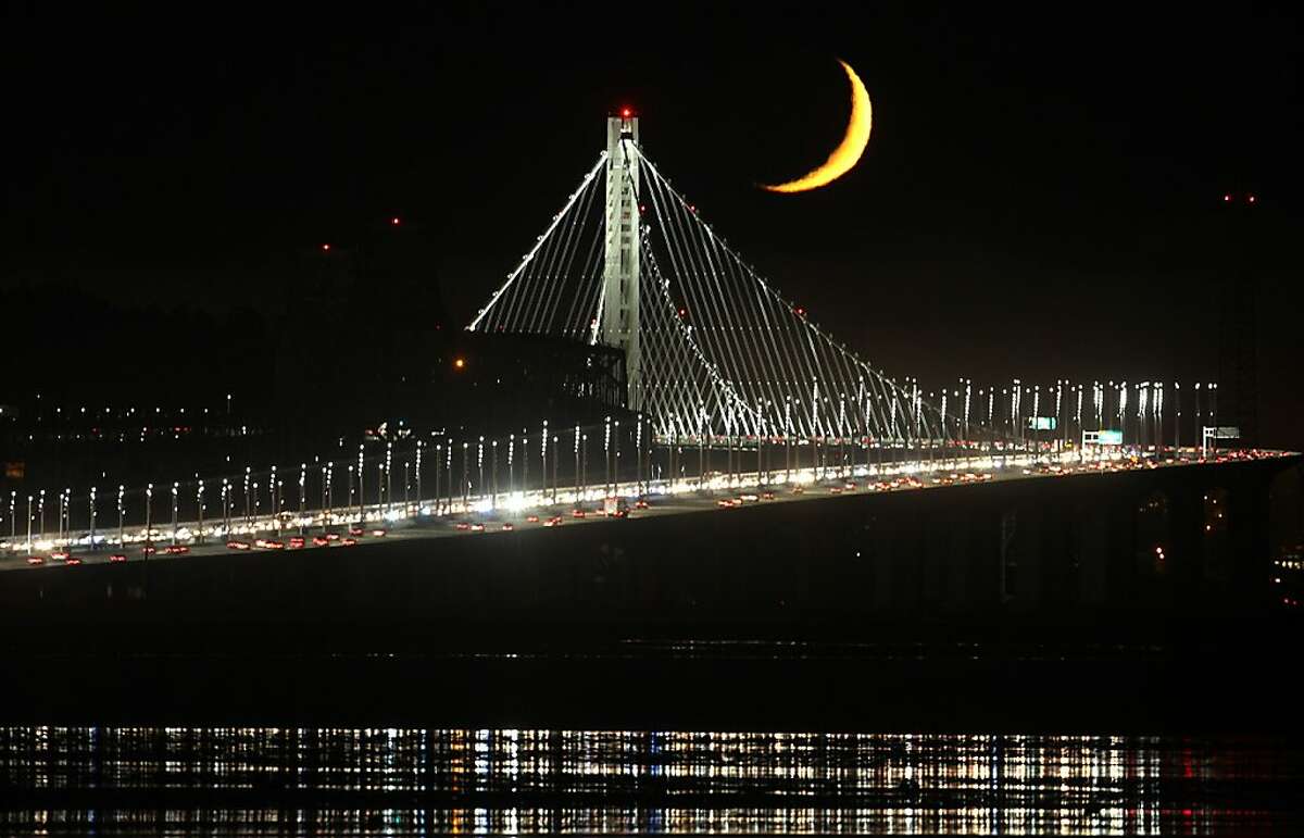 A crescent moon rises above the new tower of the Bay Bridge as seen on September 8, 2013 from Emeryville, Calif.