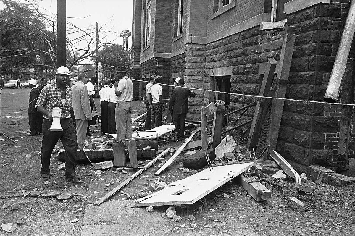 A civil defense worker and firemen walk through debris from an explosion which struck the 16th street Baptist Church, killing and injuring several people, in Birmingham, Ala. on Sept. 15, 1963. The open doorway at right is where at least four persons are believed to have died.