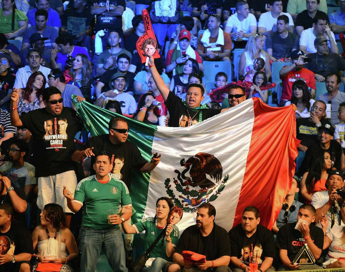 LAS VEGAS, NV - SEPTEMBER 13: Fans of boxer Canelo Alvarez cheer as they wait for the official weigh-in for the bout between Alvarez and Floyd Mayweather Jr. at the MGM Grand Garden Arena on September 13, 2013 in Las Vegas, Nevada. The fighters will meet in a WBC/WBA 154-pound title fight on September 14 in Las Vegas.