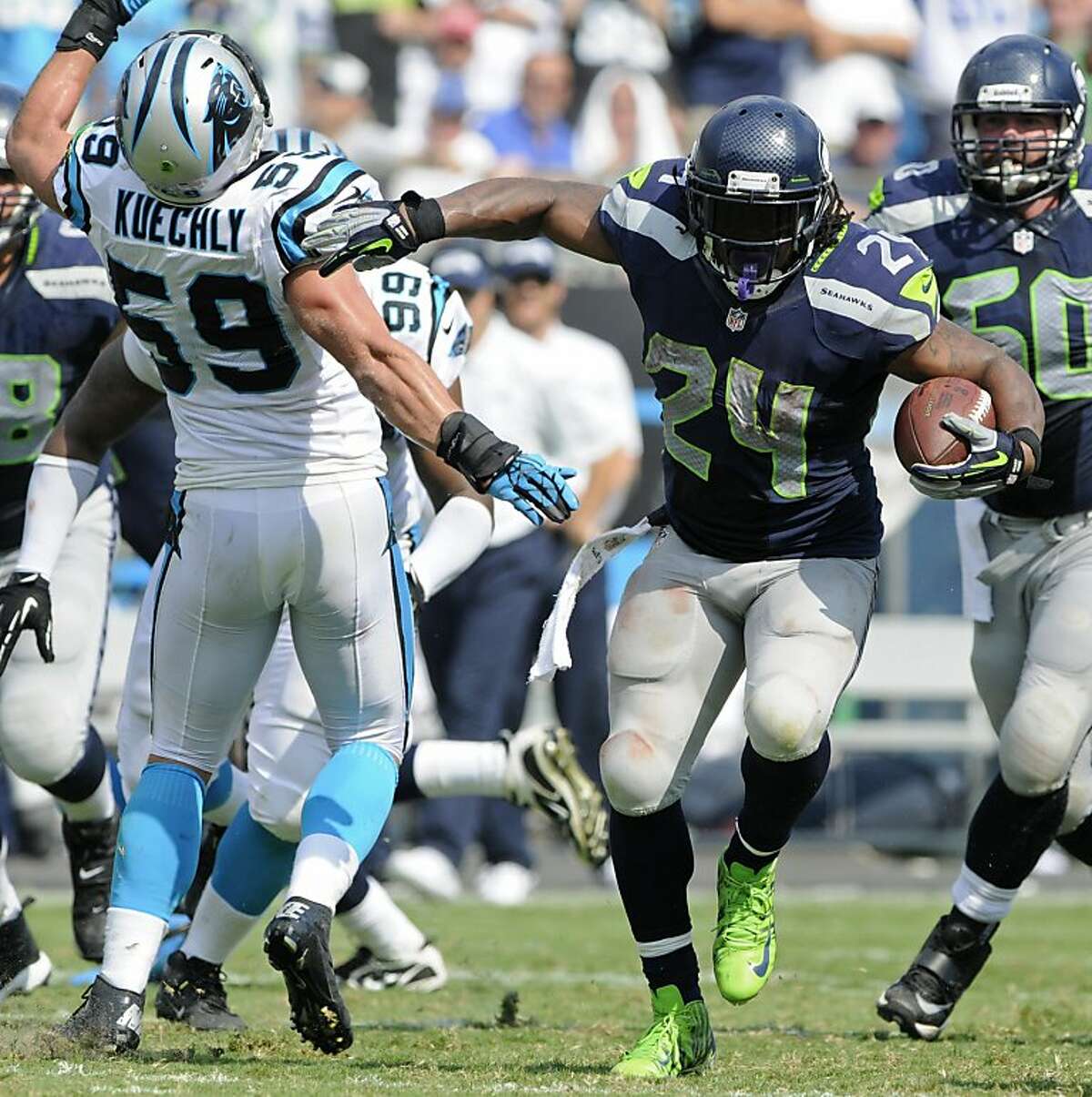 Seattle Seahawks' Marshawn Lynch (24) runs past Carolina Panthers' Luke Kuechly (59) during the second half of an NFL football game in Charlotte, N.C., Sunday, Sept. 8, 2013. Seattle won 12-7. (AP Photo/Mike McCarn)
