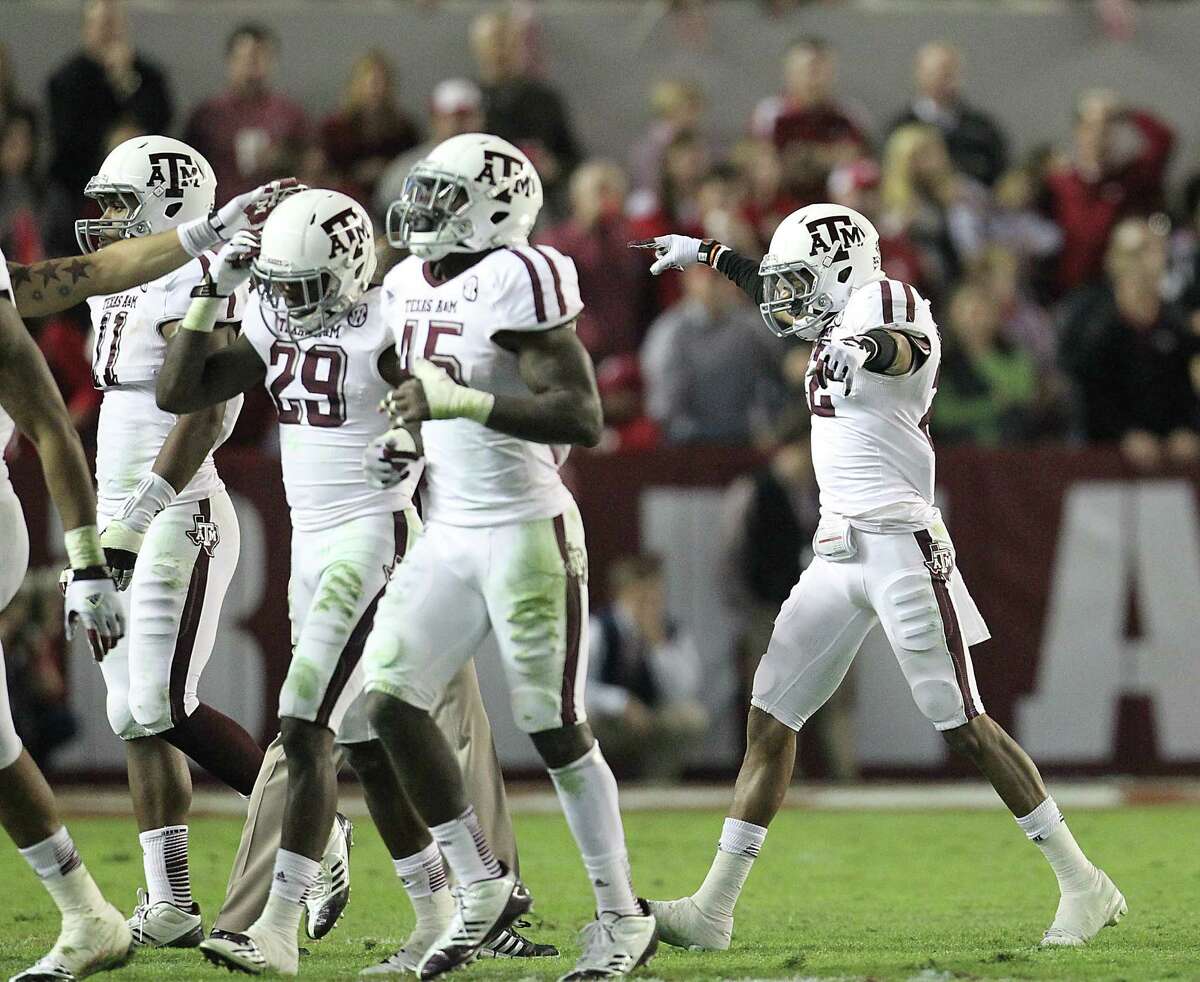 Texas A&M's Dustin Harris (right) follows his teammates off the field after he recovered a fumble that set up the Aggies' eventual game-sealing touchdown.