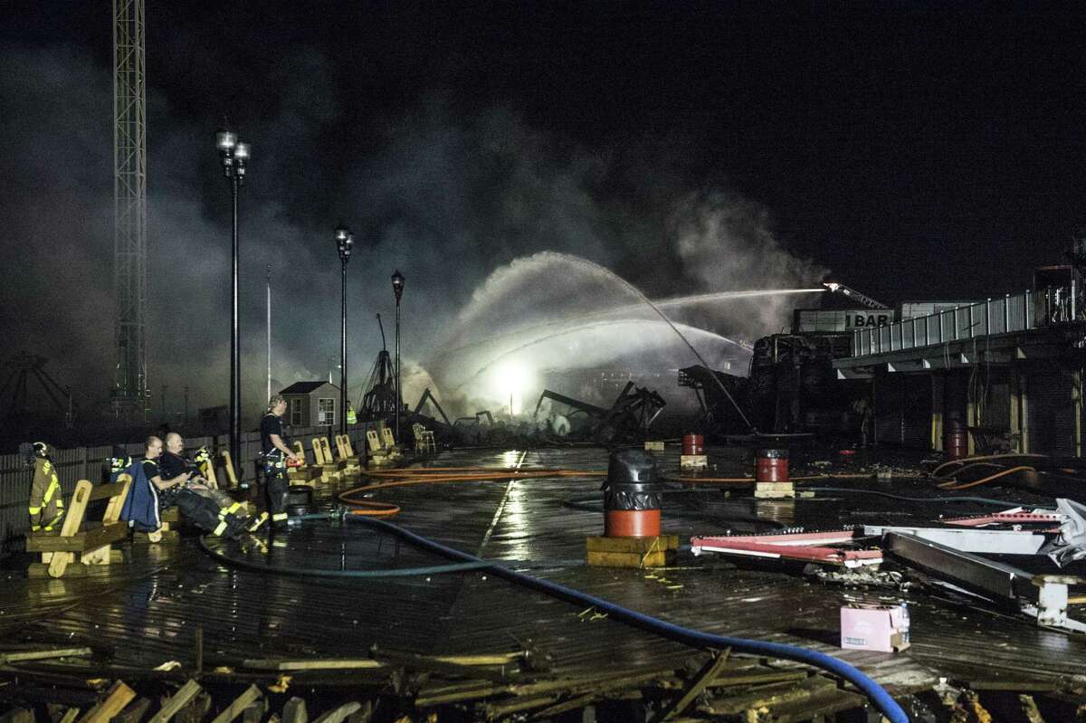 Fire crews work into the early morning hours Friday on a beachfront boardwalk fire in Seaside Heights, N.J. It left dozens of businesses burned down along the same stretch of boardwalk that was hard hit during Hurricane Sandy less than one year ago.