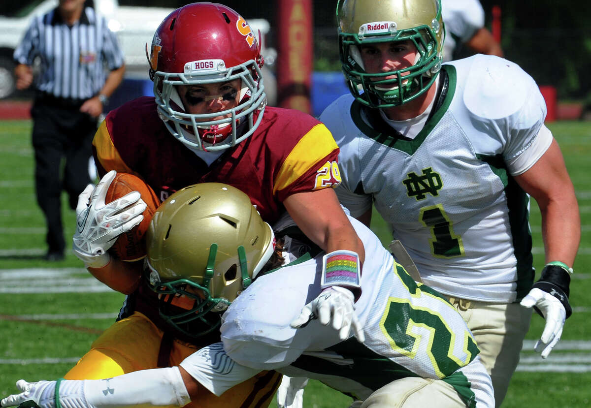 St. Joseph's Lars Pedersen gets tackled by Notre Dame of West Haven's Zachary Cotrancesco, during high school football action in Trumbull, Conn. on Saturday September 14, 2013. Coming in from behind is Salvatore Esposito.