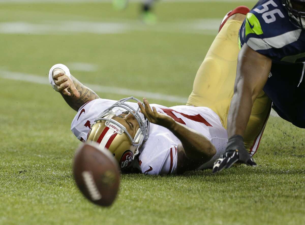 San Francisco 49ers quarterback Colin Kaepernick lies on the turf after fumbling the football in the first half of an NFL football game against the Seattle Seahawks, Sunday, Sept. 15, 2013, in Seattle. (AP Photo/Elaine Thompson)