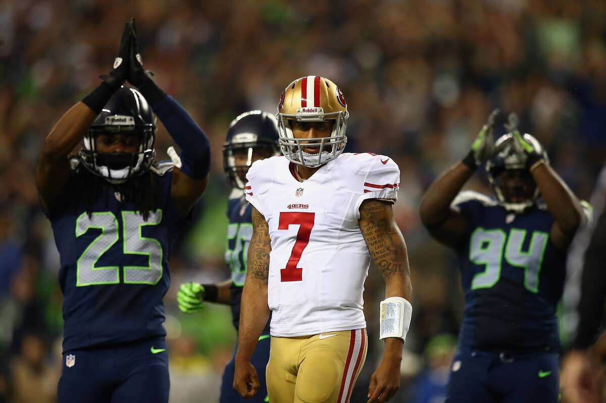 SEATTLE, WA - SEPTEMBER 15: Colin Kaepernick #7 of the San Francisco 49ers looks on as Richard Sherman #25 and D'Anthony Smith #94 of the Seattle Seahawks celebrate a saftey during their game at Qwest Field on September 15, 2013 in Seattle, Washington. (Photo by Jonathan Ferrey/Getty Images)