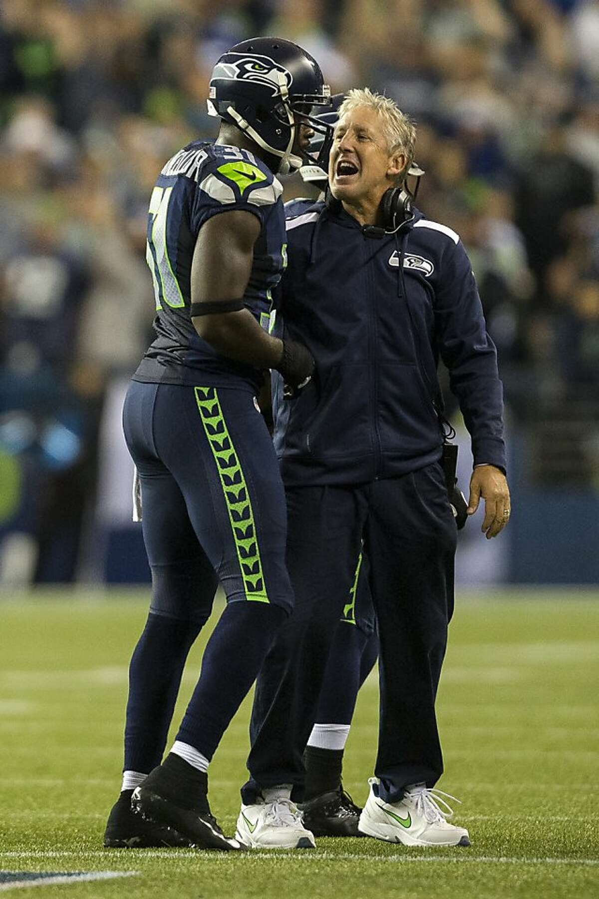 Head coach Pete Carroll, right, welcomes players to the sideline following a play in the Seahawks' favor during the first half of the home opener Sunday, September 15, 2013, at CenturyLink Field in Seattle. The Seahawks led the 49ers 5-0 at the half. (Jordan Stead, seattlepi.com)