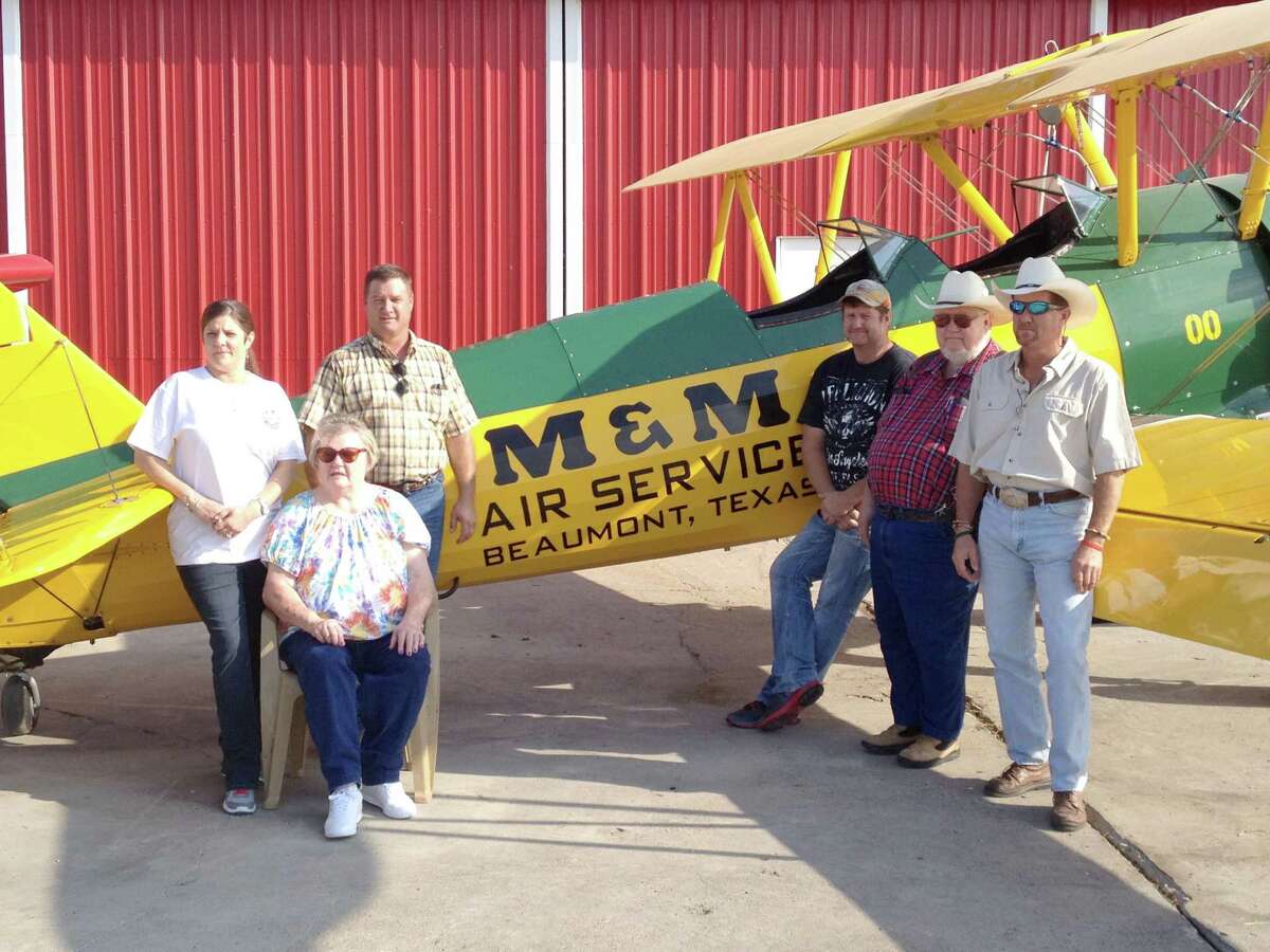 The Mitchell family stands in front of one of the first planes that launched their business. The Stearman biplane was among the first to plant rice by air in Texas. M&M Air Service from left to right: Lisa, Gail, Mark, Andy, George and David Mitchell.