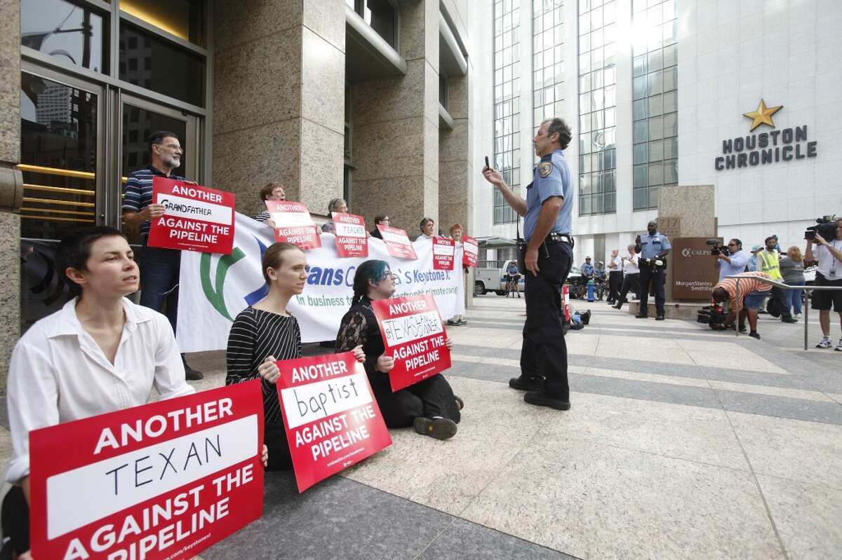 Pipeline protestors chant and hold signs in downtown Houston on Sept. 16, 2013.