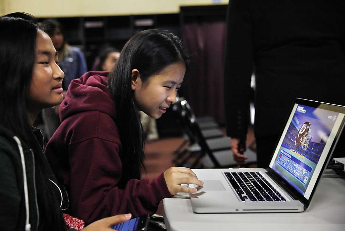 Thurgood Marshall sophomore Hanh Nguyen (right), 15, and Thurgood Marshall freshman Christina Wong (left), 14, play "Financial Football" on a laptop in the 49er locker room at Candlestick Park on Monday, September 16, 2013 in San Francisco, Calif. after a group of students played "Financial Football" in the 49ers locker room with 49ers Joe Staley (not shown) and Colt McCoy (not shown) , California State Controller John Chiang (not shown) and California State Board of Equalization member Betty Yee (not shown) on Monday, September 16, 2013 in San Francisco, Calif.