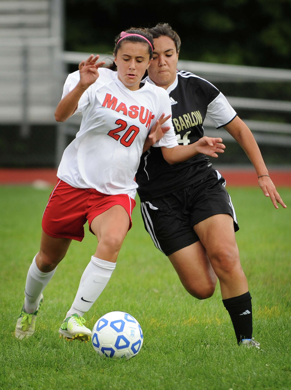 Masuk's Nicole Yanouzas, left, and Joel Barlow's Alejandra Avila chase down a ball at midfield during Barlow's 1-0 victory in their girls soccer matchup at Masuk High School in Monroe, Conn. on Monday, September 16, 2013.