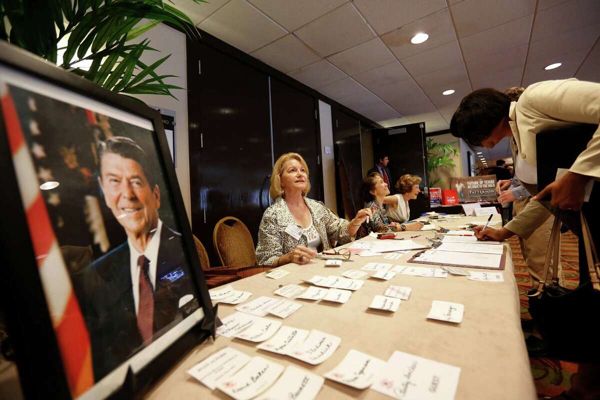 Patricia Henderson, center, helps check members in during a debate between the four candidates for lieutenant governor, Monday, at the Republican's women's forum at the Doubletree hotel in Houston.