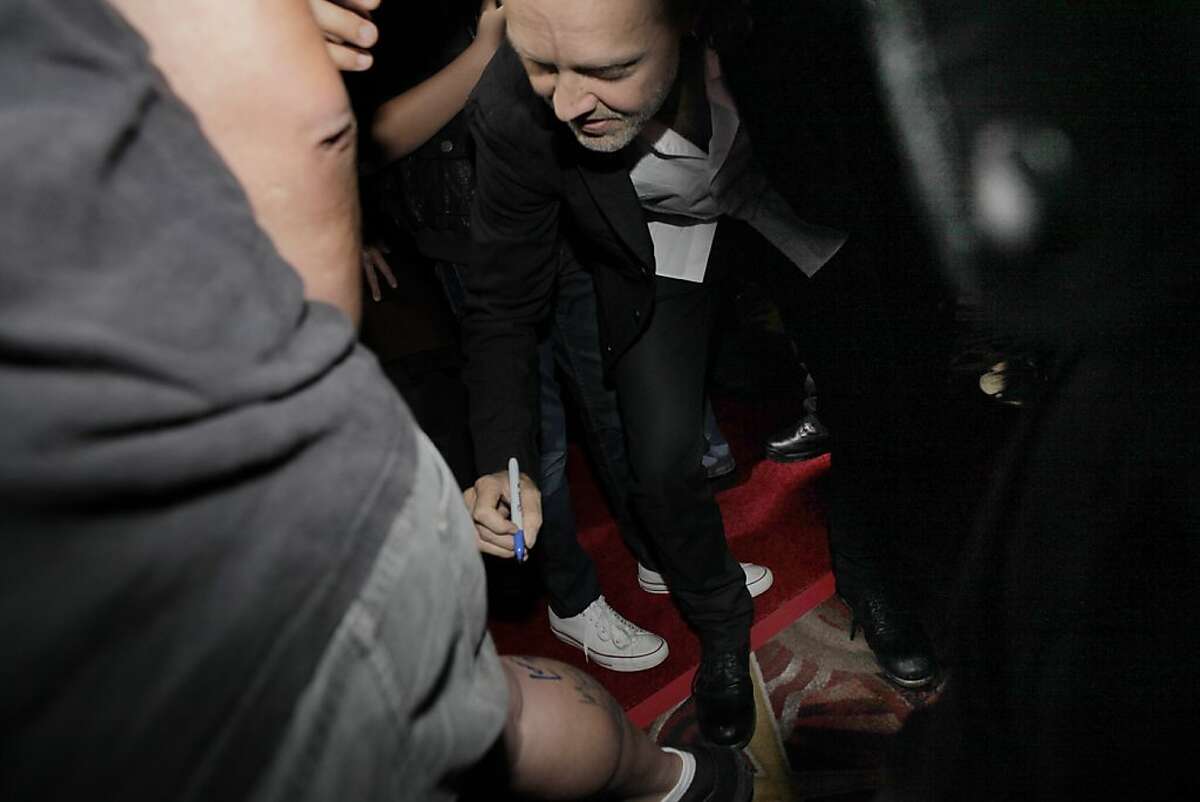 Lars Ulrich signs the calf of fan Dave Silva as members of the band Metallica attended the U.S. premiere of the movie, "Metallica Through the Never," at the Metreon Theater in San Francisco, Calif., on Monday, September 16, 2013.
