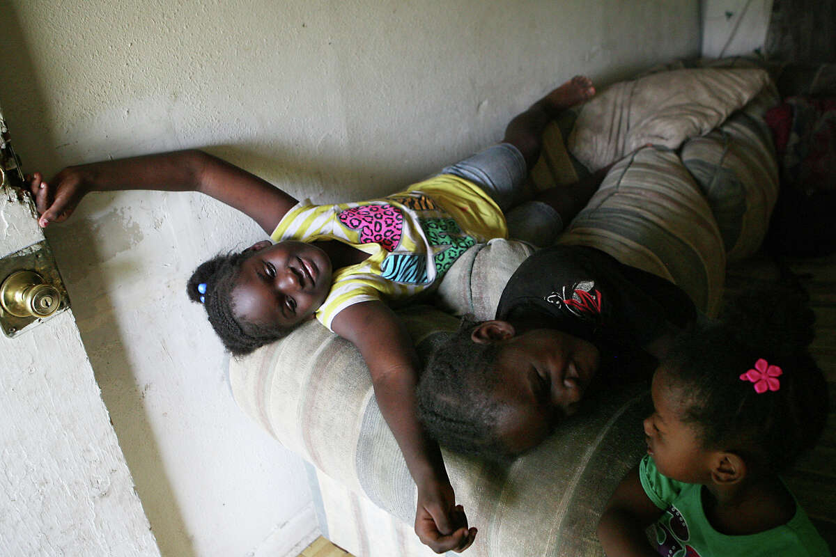 Alandra Hardeman, 6, her brother Damonate Hardeman, 4 and their cousin Princess Hodje, 2, play around on their couch Aug. 21, 2013. The family relies on food stamps for their meals and it may be getting cut soon.