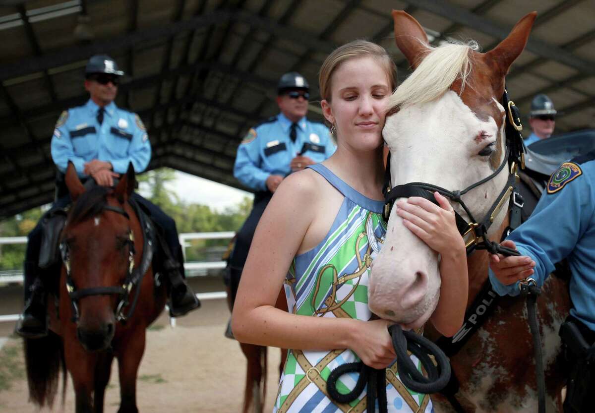 Katherine Richards, 24, embraces "Smash" after giving the Houston Police Foundation a $10,000 check to sponsor "Smash" to become a the newest member of HPD Mounted Patrol on Wednesday, Sept. 18, 2013, in Houston. Katherine Richards spearheaded the fundraising efforts with her other special needs friends. The funds will sponsor "Smash" for two years, and girls plan to continue to fundraise money for the deaf horse.