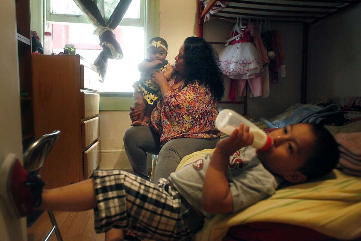 Sonia Cauich (center), holds her daughter Natalia Dorantes (left), 6 months, as she cares for her son, Anthony Hernandez (bottom), 3, and daughter Natalia Dorantes at home on Friday, September 20, 2013 in San Francisco, Calif.