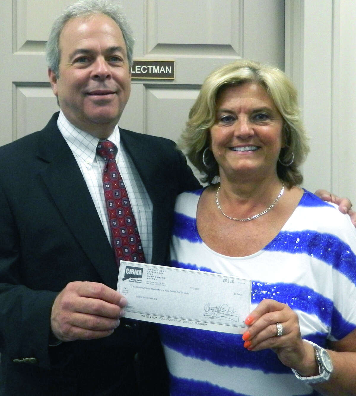 Steven Bixler, vice president for underwriting, marketing and member relations of the Connecticut Interlocal Risk Management Agency, presents a check for $2,749, the town's pro-rated share of CIRMAís $3 million membersí equity distribution for 2013,.to Roxbury First Selectman Barbara Henry. August 2013 Courtesy of the Town of Roxbury