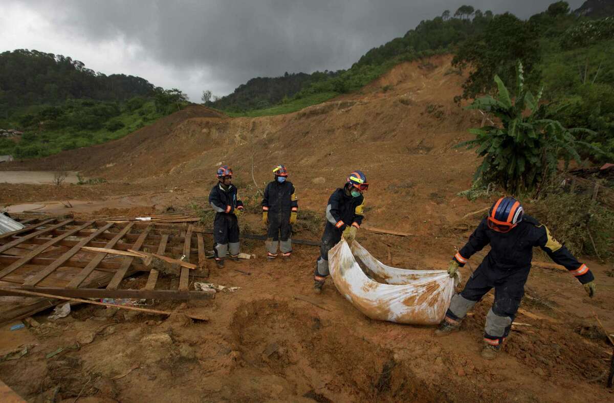 Soldiers remove the body of a woman who was recovered from the site of a landslide in La Pintada. The village was the scene of the single greatest tragedy in destruction wreaked by Manuel and Ingrid, which pounded both of Mexico's coasts.