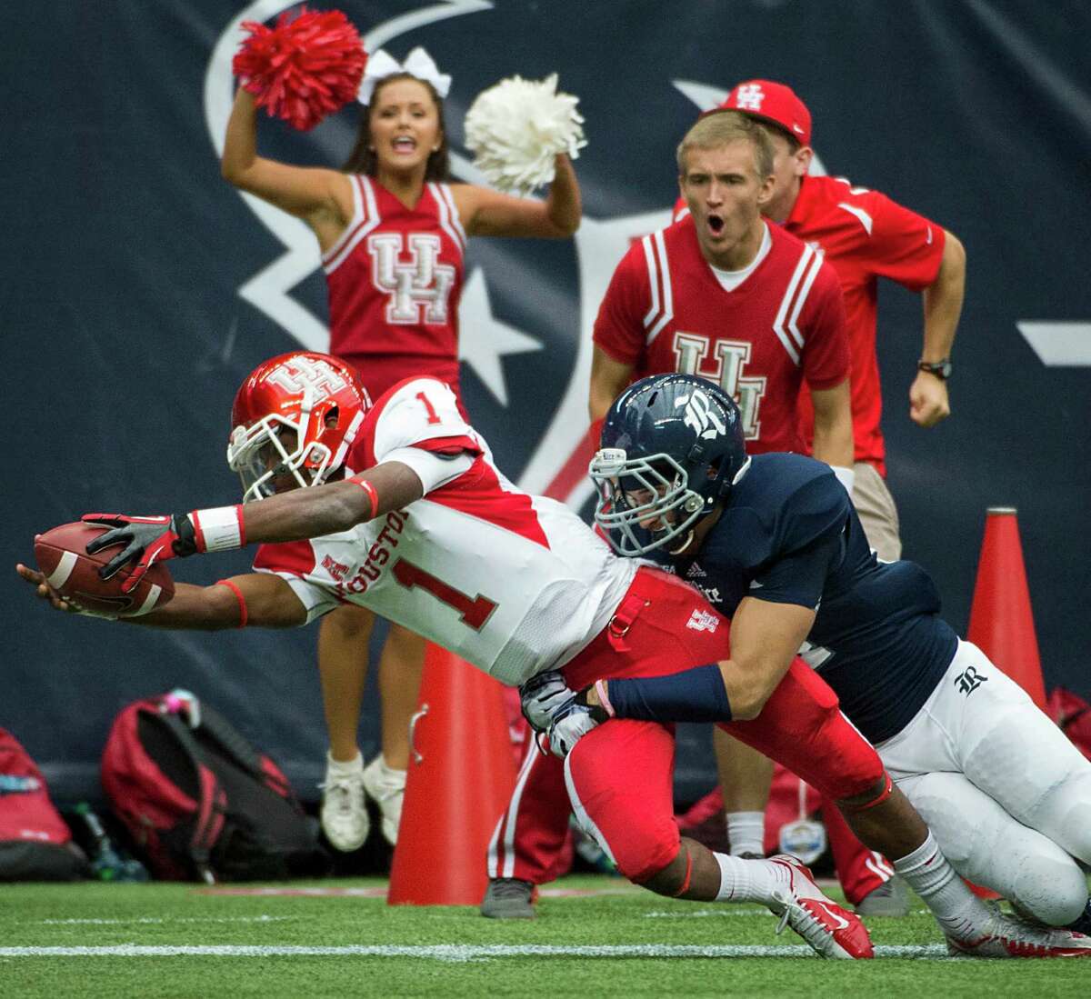 Houston quarterback Greg Ward (1) comes up short of the touchdown as he dives toward the end zone as Rice safety Paul Porras defends during the first half of the annual Bayou Bucket college football game at Reliant Stadium, Saturday, Sept. 21, 2013, in Houston. ( Smiley N. Pool / Houston Chronicle )