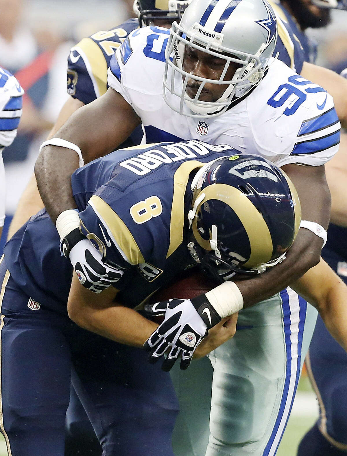 TOP: Cowboys lineman George Selvie wraps up Rams quarterback Sam Bradford for a sack during Dallas' victory.