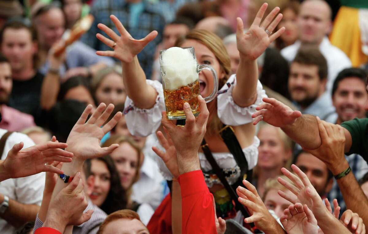 People celebrate the opening ceremony in the "Hofbraeuzelt' beer tent of the 180th Bavarian "Oktoberfest" beer festival in Munich, southern Germany, Saturday, Sept. 21, 2013. The world's largest beer festival, to be held from Sept. 21 to Oct. 6, 2013 will attract more than six million guests from around the world.
