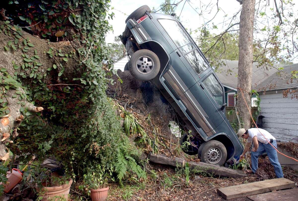 Javier Blas, 20, of Beaumont, Texas, checks out the front end of his Chevy Blazer in the backyard of his Beaumont home. Hurricane Rita left the SUV in a precarious posistion when she blew through the area. Enterprise file photo