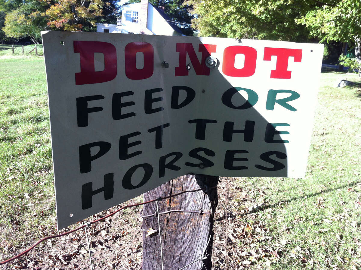 One of the several signs along the fence at Glendale Farms in Wheelers Farms Road in Milford urging visitors to steer clear of the horses. The Supreme Court will hear arguments on a lower court ruling defining all horses as "vicious." An accident at the farm in 2006 prompted the case.