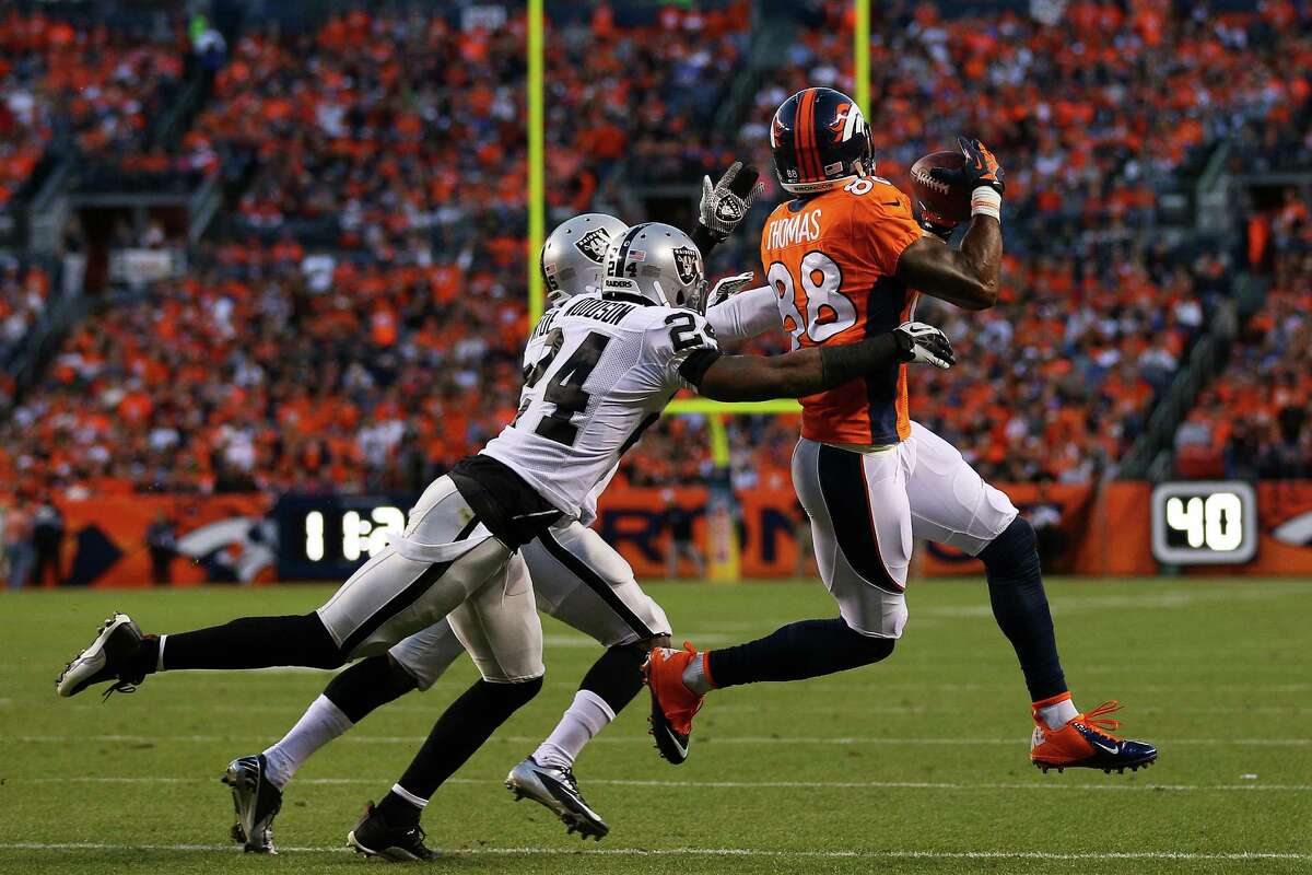 DENVER, CO - SEPTEMBER 23: Demaryius Thomas #88 of the Denver Broncos completes a 22-yard first down pass reception against the defense of Charles Woodson #24 and DJ Hayden #25 of the Oakland Raiders in the first quarter at Sports Authority Field at Mile High on September 23, 2013 in Denver, Colorado. (Photo by Justin Edmonds/Getty Images) ORG XMIT: 175878502