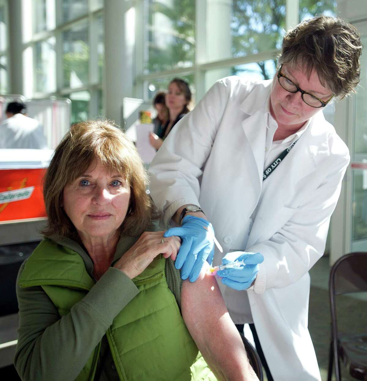 Anita Barkan gets a flu shot from Maryalice Flynn at Government Center on Tuesday, Sept. 24, 2013.